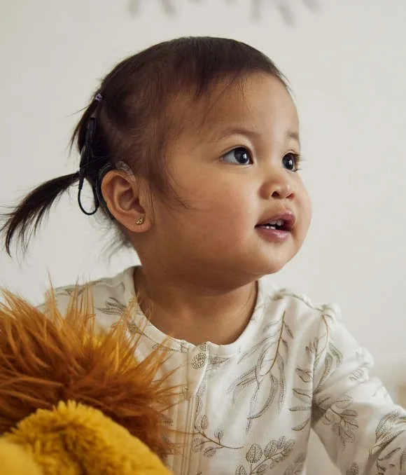 A young child wearing a Cochlear sound processor